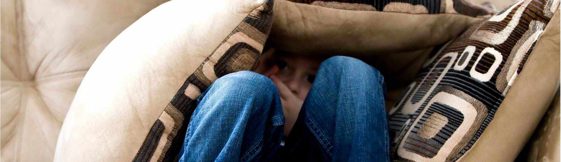 a child hiding under cushions during counselling